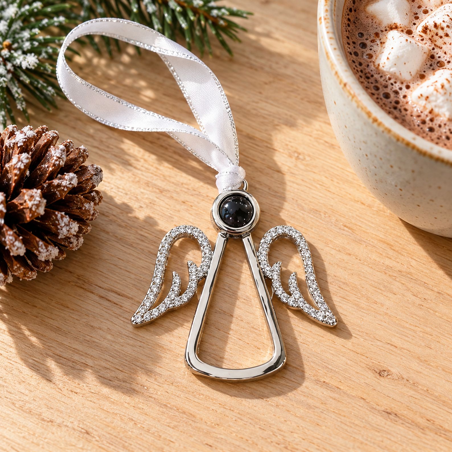 Angel wings memorial ornament next to a pine cone showing 5cm scale