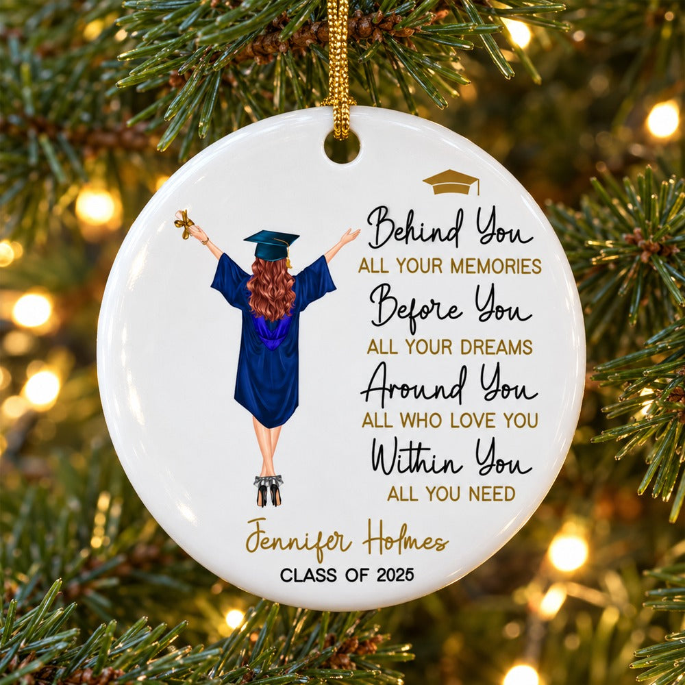 Personalized graduation ceramic ornament hanging on a Christmas tree branch with warm lights