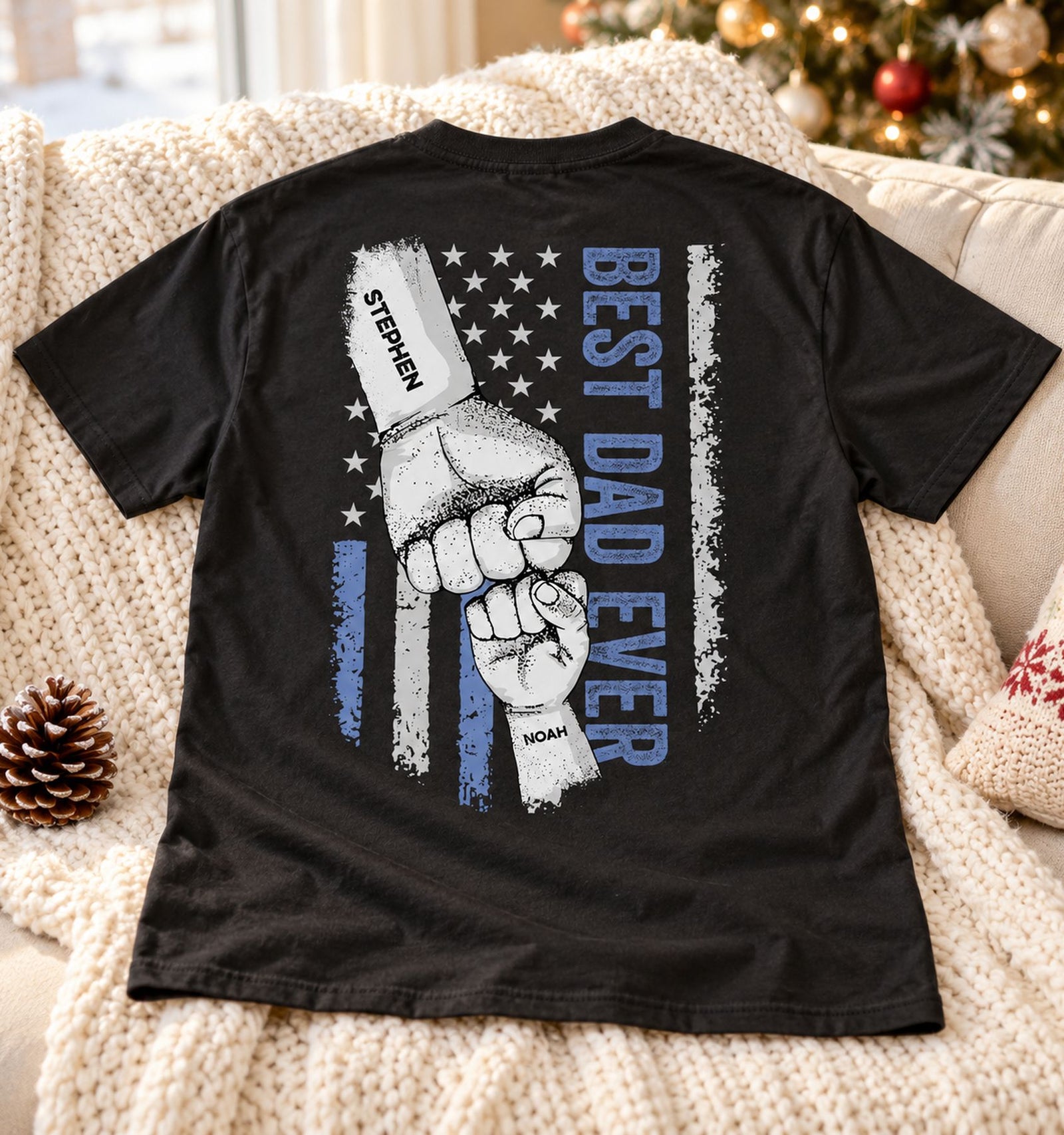 Best Dad Ever personalized back printed black t-shirt laid on a cozy holiday sofa