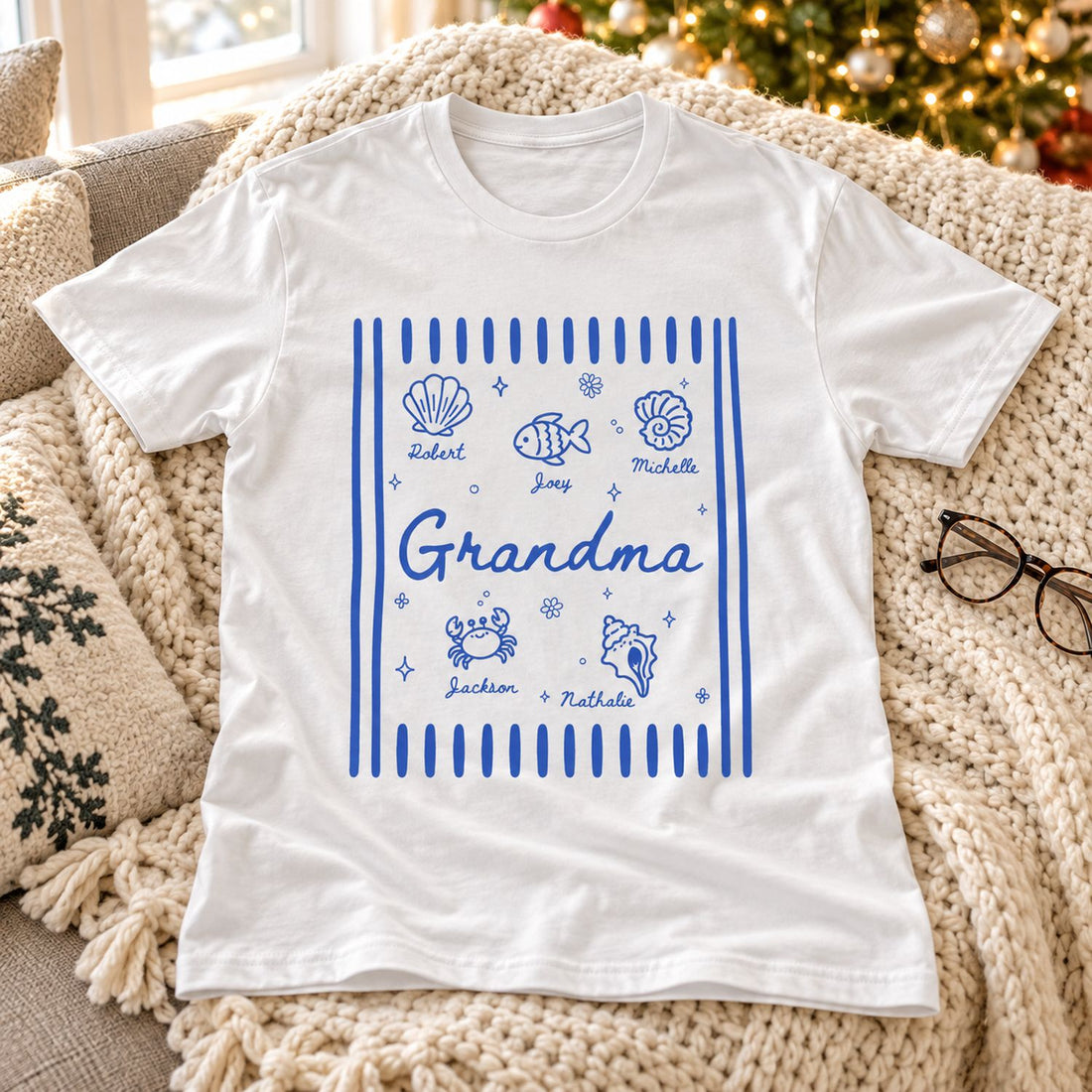Personalized Grandma summer shirt laid on a cozy sofa with holiday tree in soft background