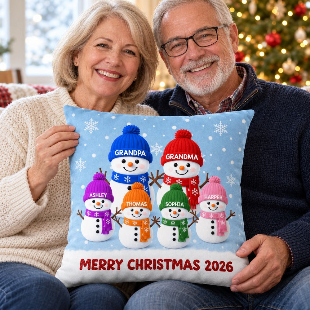 Grandma and Grandpa holding personalized Christmas snowman family pillow on sofa