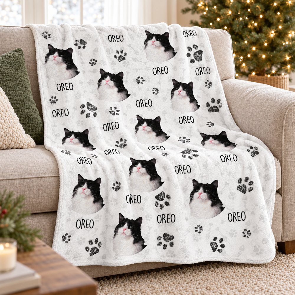 Custom cat photo fleece blanket draped on a cozy sofa next to a Christmas tree