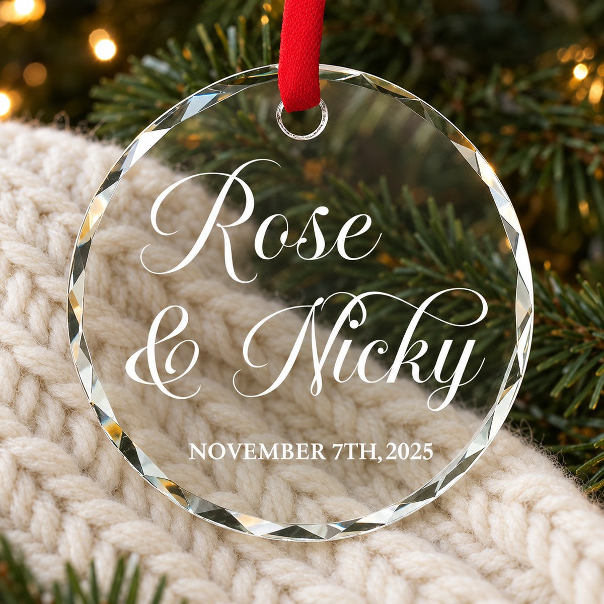 Couple personalized glass ornament with names and date lying on cozy holiday knit fabric