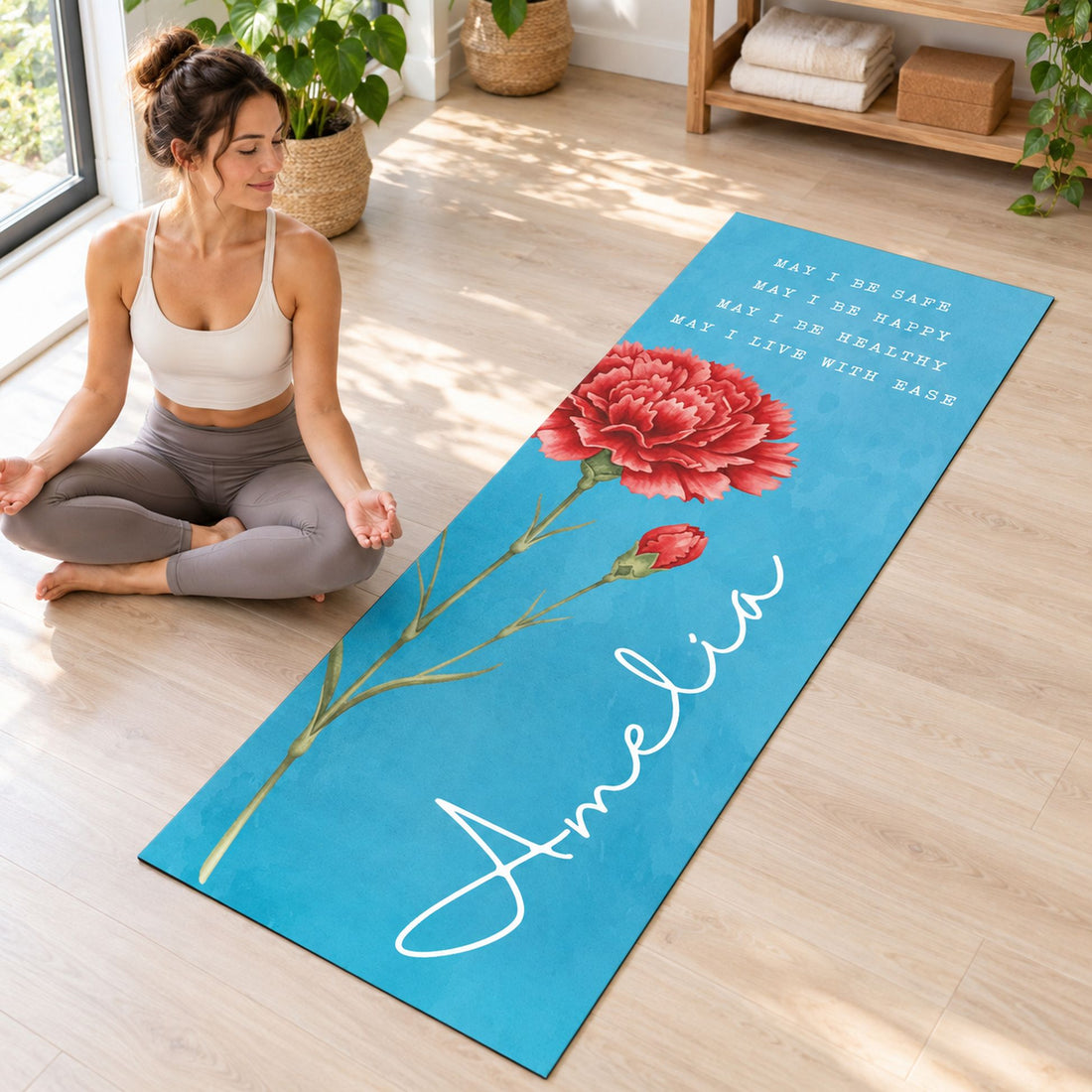 Woman sitting in lotus pose on personalized teal birth flower yoga mat