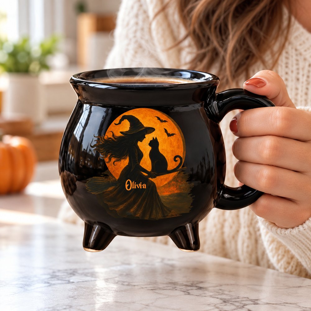 Woman in cozy sweater holding a steaming custom name Halloween witchy black cauldron coffee mug