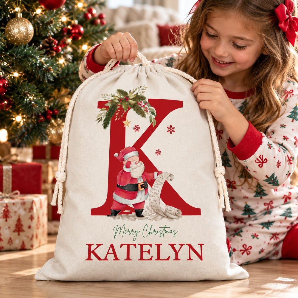 Child opening personalized Katelyn Santa gift bag under the Christmas tree on Christmas morning