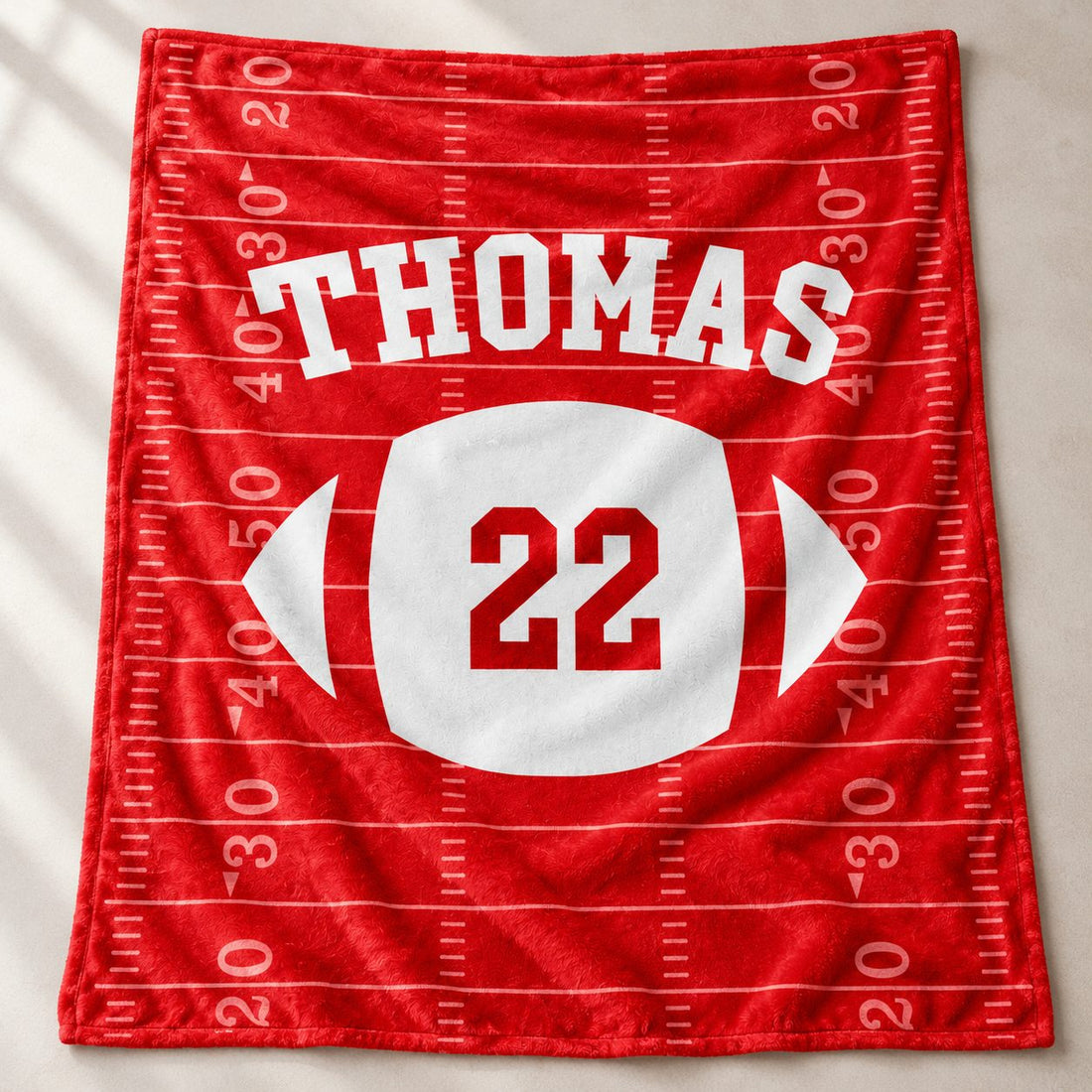 Close-up detail of soft plush fleece texture and vibrant print on custom football blanket