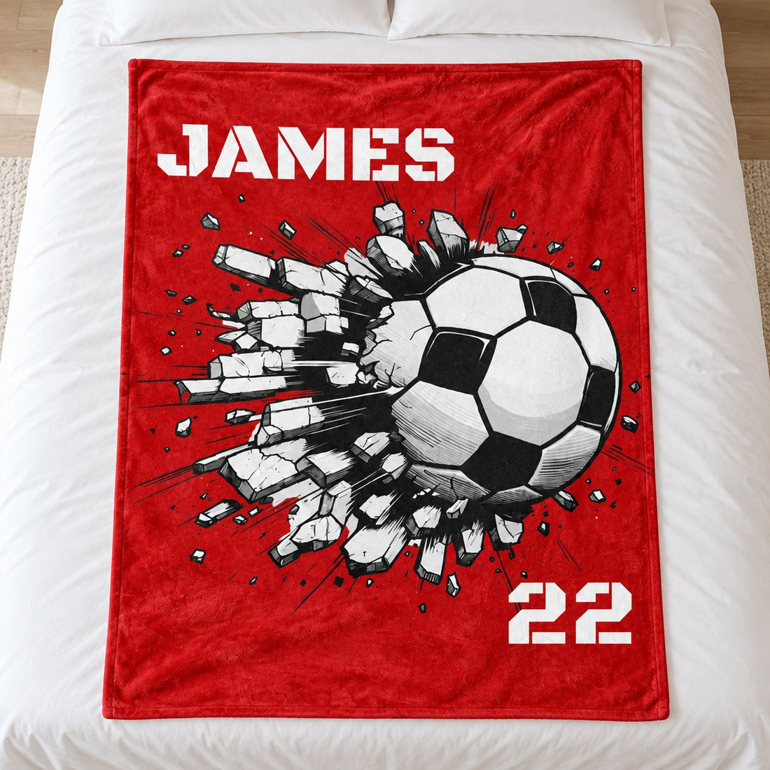 Custom Name and Number Soccer blanket spread flat on a white bed showing the red JAMES 22 design