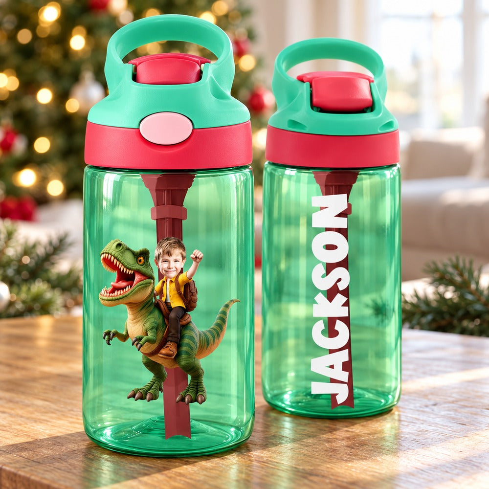 Personalized kids dinosaur water bottle on table with Christmas tree background