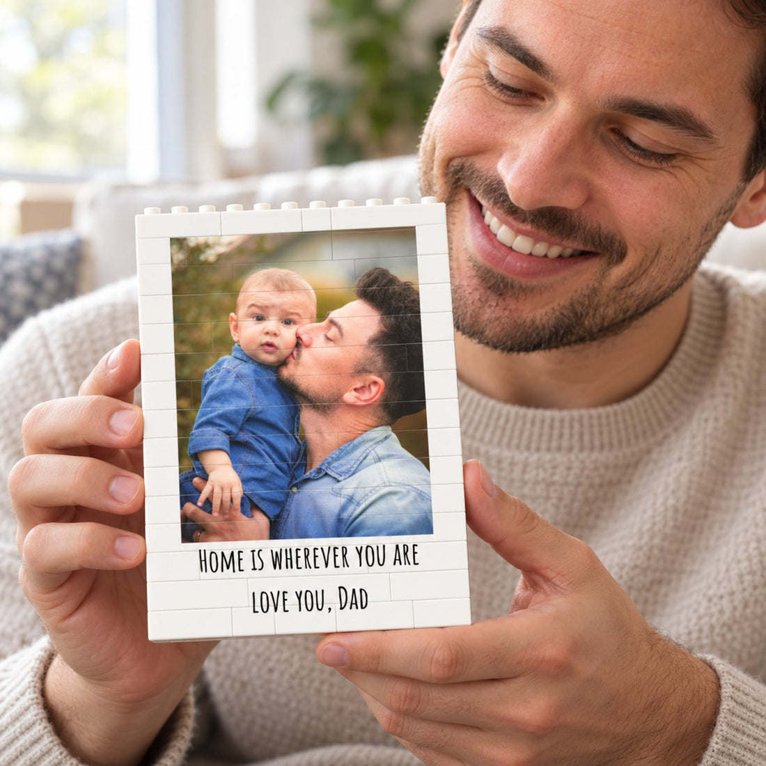 Happy dad holding his personalized photo building brick block gift on a sofa