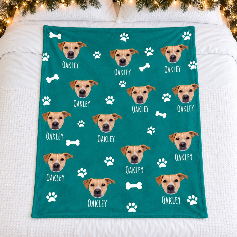 Custom photo dog blanket with Oakley print spread flat on a white bed with holiday greenery