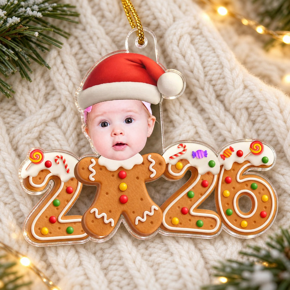 Custom photo baby gingerbread 2026 acrylic ornament lying flat on a festive knit blanket