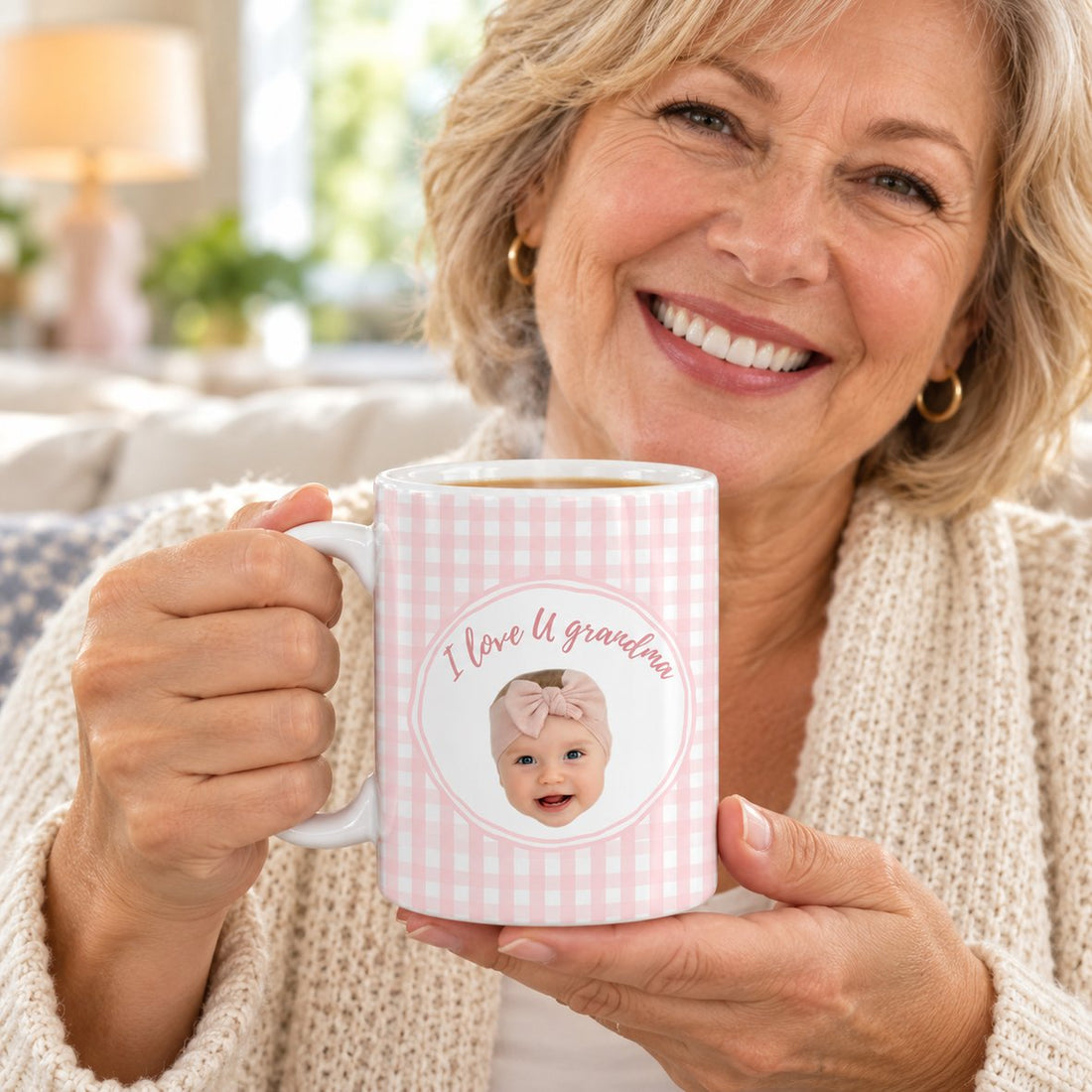 Grandma holding her custom grandkid face coffee mug with steam rising in a bright living room