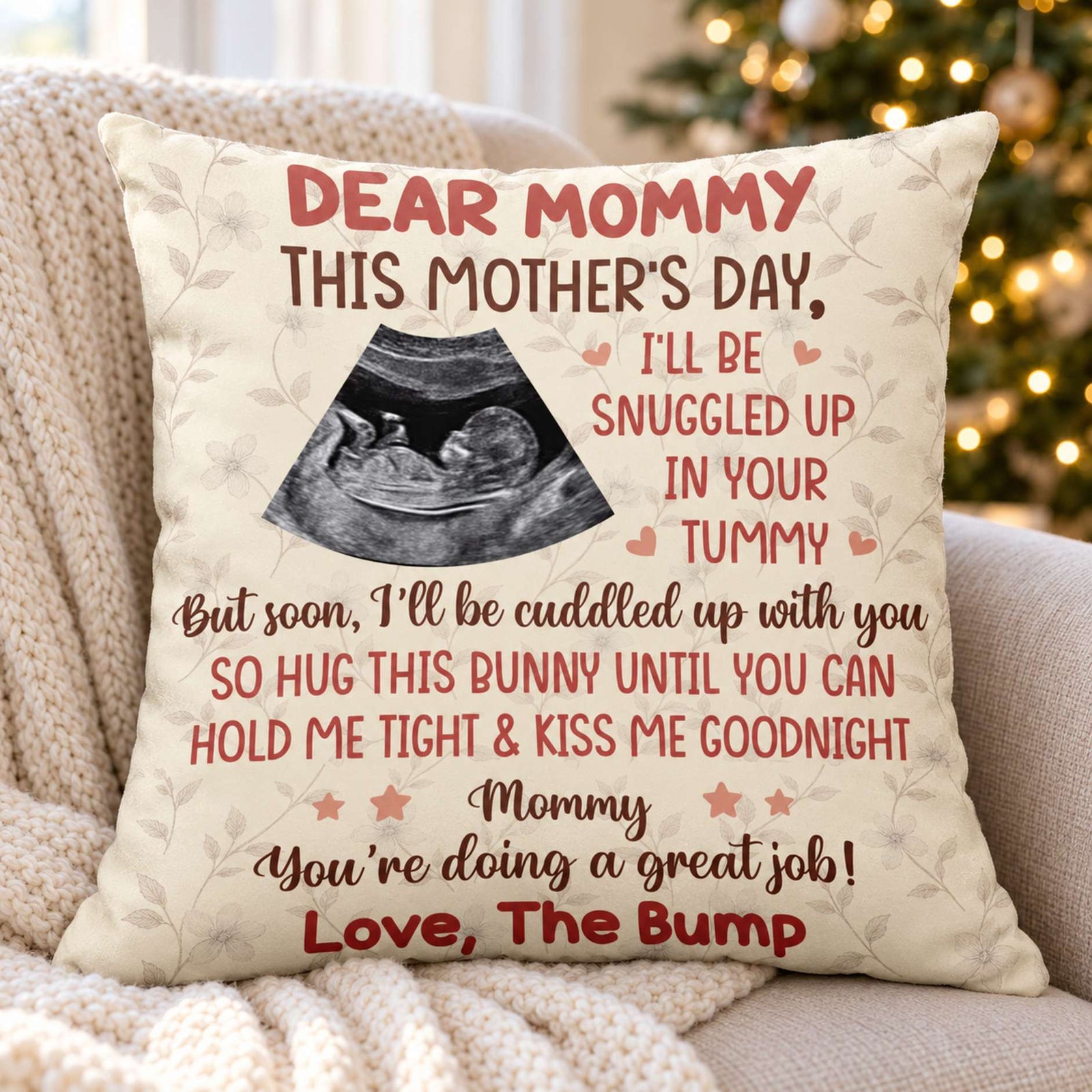 Personalized Dear Mommy ultrasound pillow on a cozy armchair with holiday tree lights
