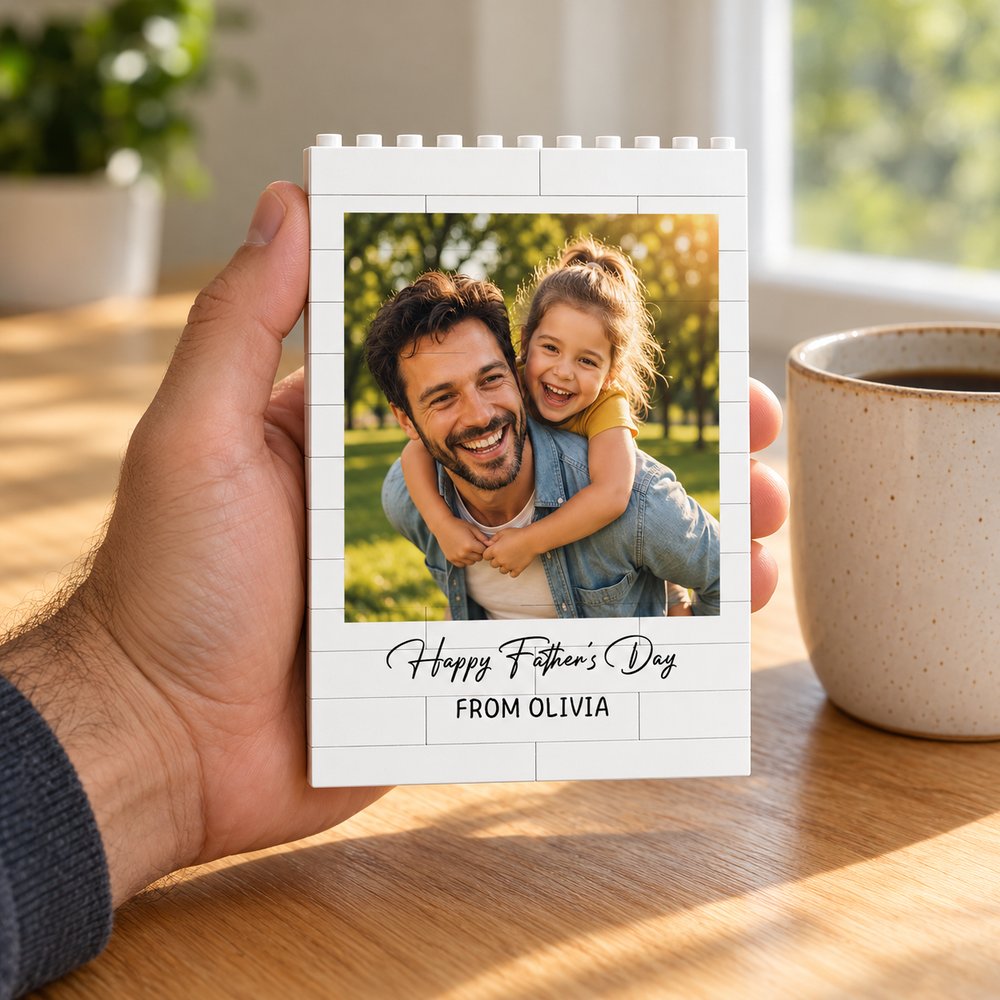 Hand holding personalized Father's Day building brick block next to mug for size scale