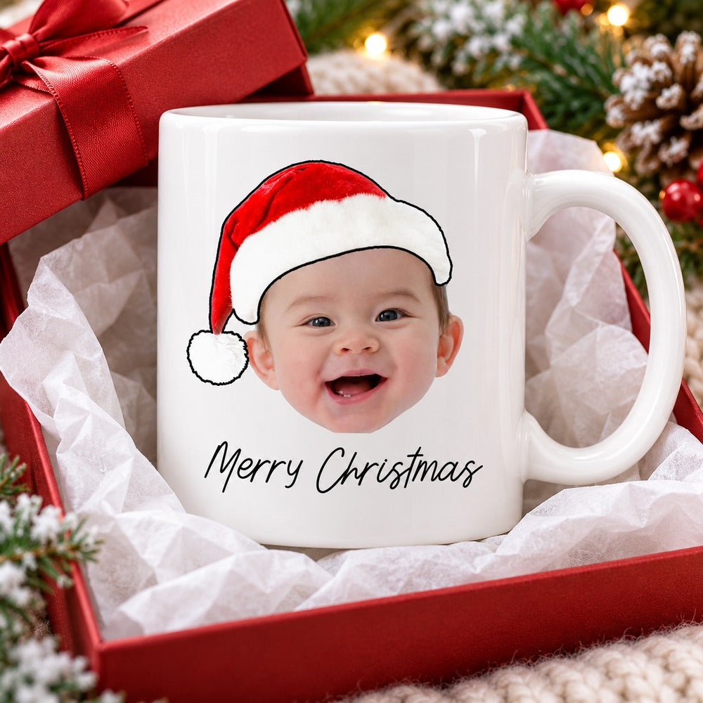 Personalized Merry Christmas baby face mug in tissue paper next to a festive red gift box