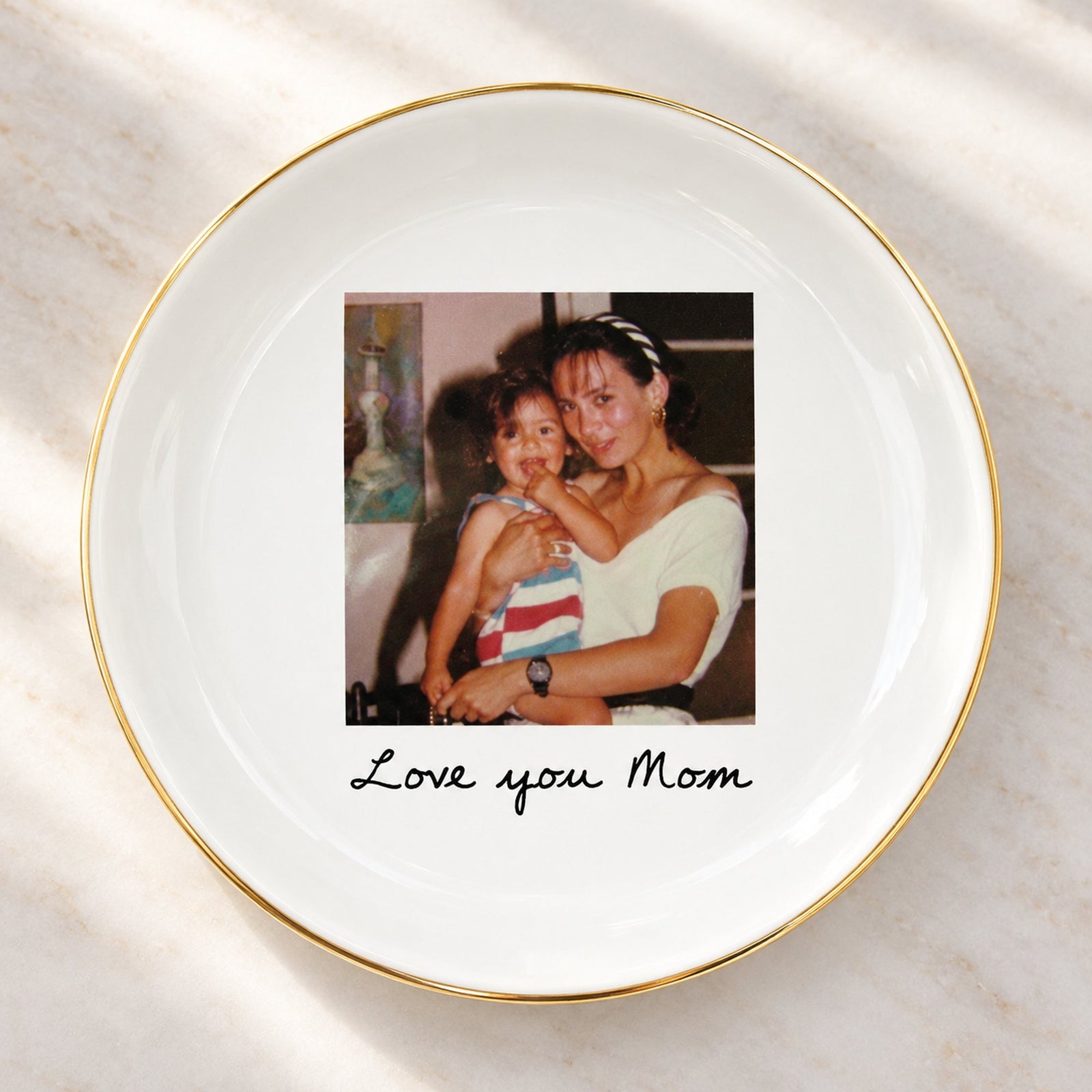 Close-up detail of glossy ceramic photo jewelry dish gold rim and custom print