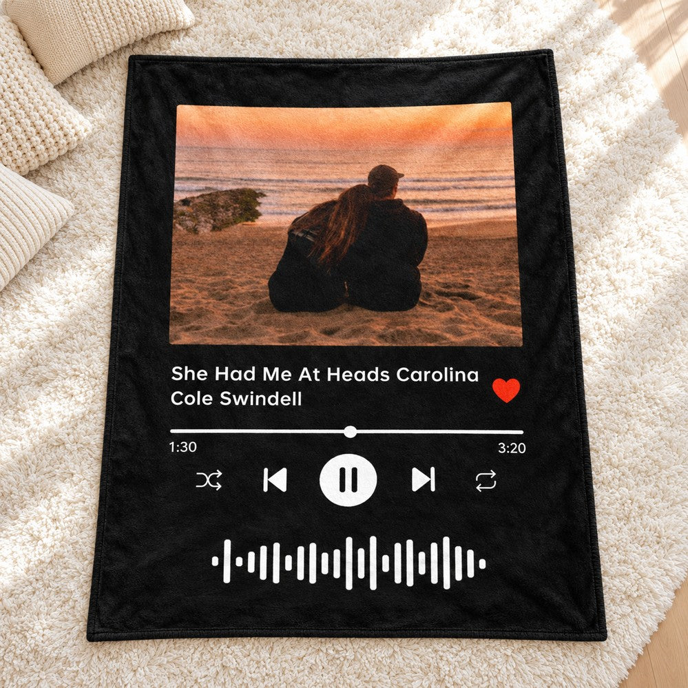 Personalized couple music player throw blanket laid flat on a cozy living room rug