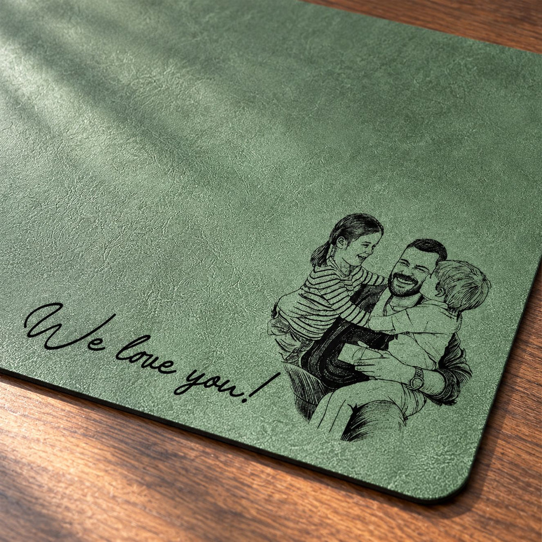 Close-up of custom sketch line art and We love you script on green desk mat
