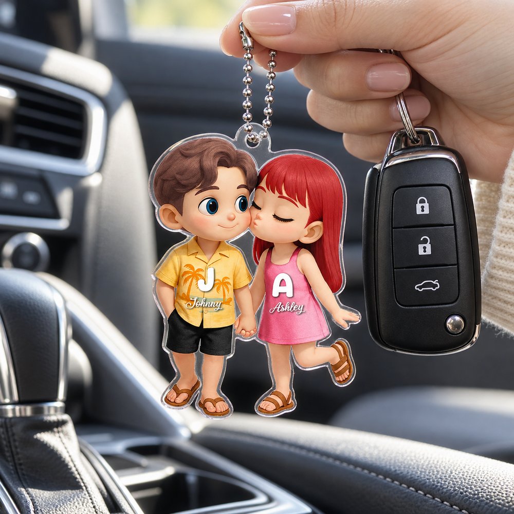 Hand holding personalized couple acrylic car hanger next to car key for size scale