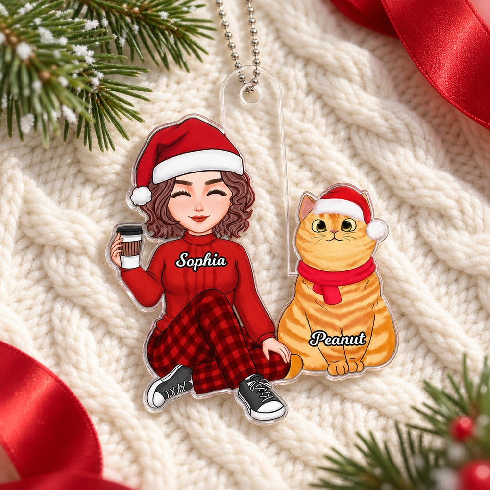 Personalized cat lover acrylic Christmas ornament lying flat on a cream knit blanket with greenery