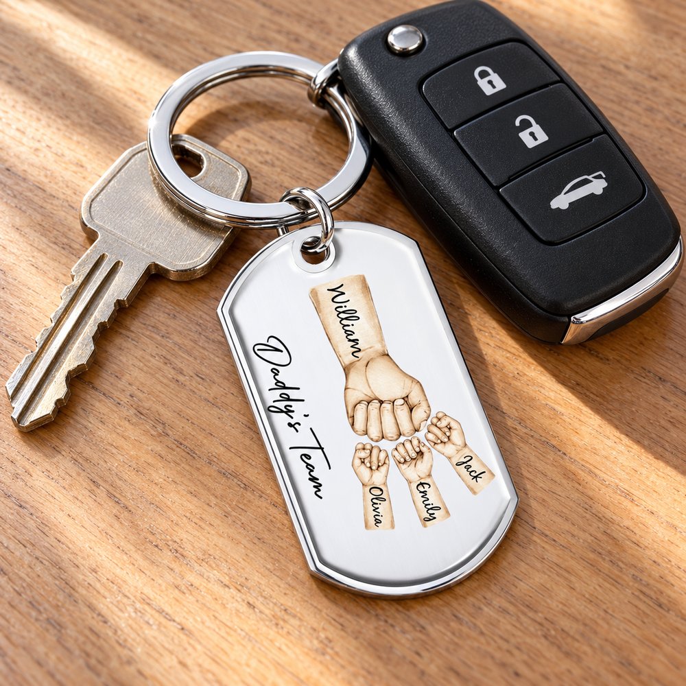 Daddy's Team personalized stainless steel keychain attached to car keys on a wooden entryway table