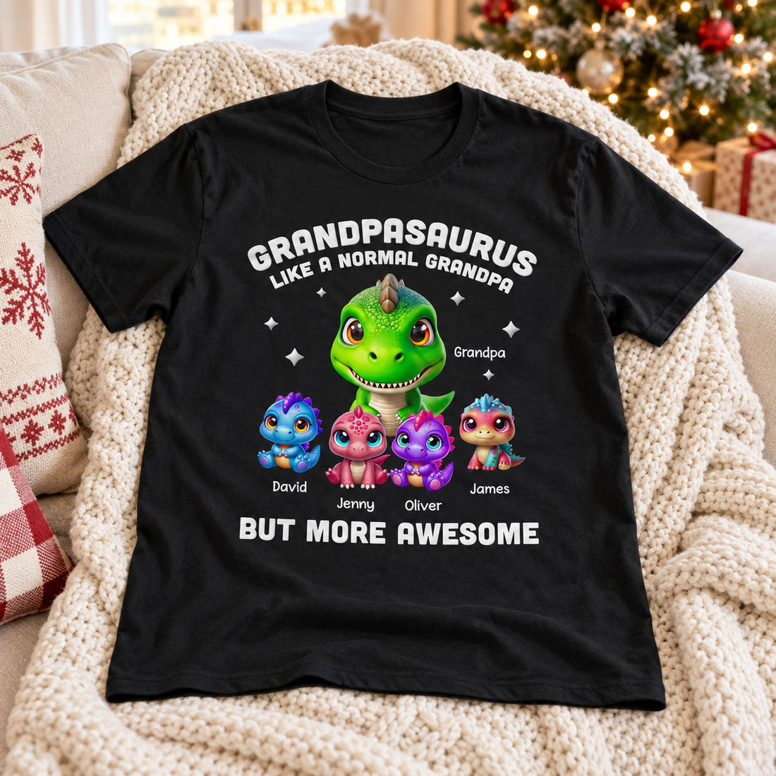 Personalized Grandpasaurus dinosaur t-shirt laid on a cozy sofa near a Christmas tree