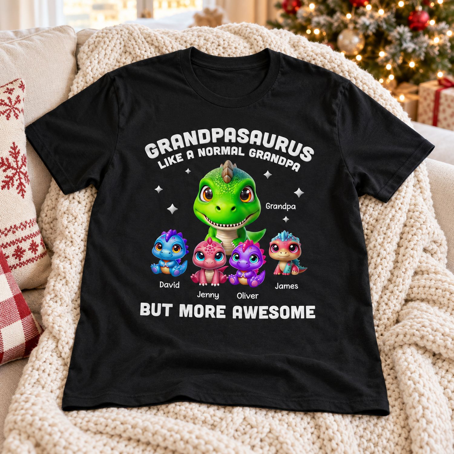 Personalized Grandpasaurus dinosaur t-shirt laid on a cozy sofa near a Christmas tree