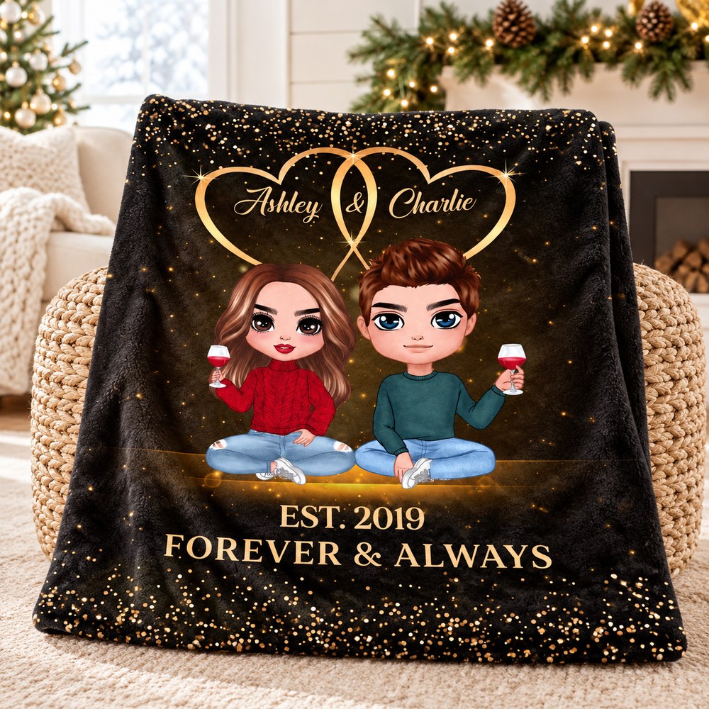 Folded custom couple blanket resting on a woven ottoman with holiday greenery