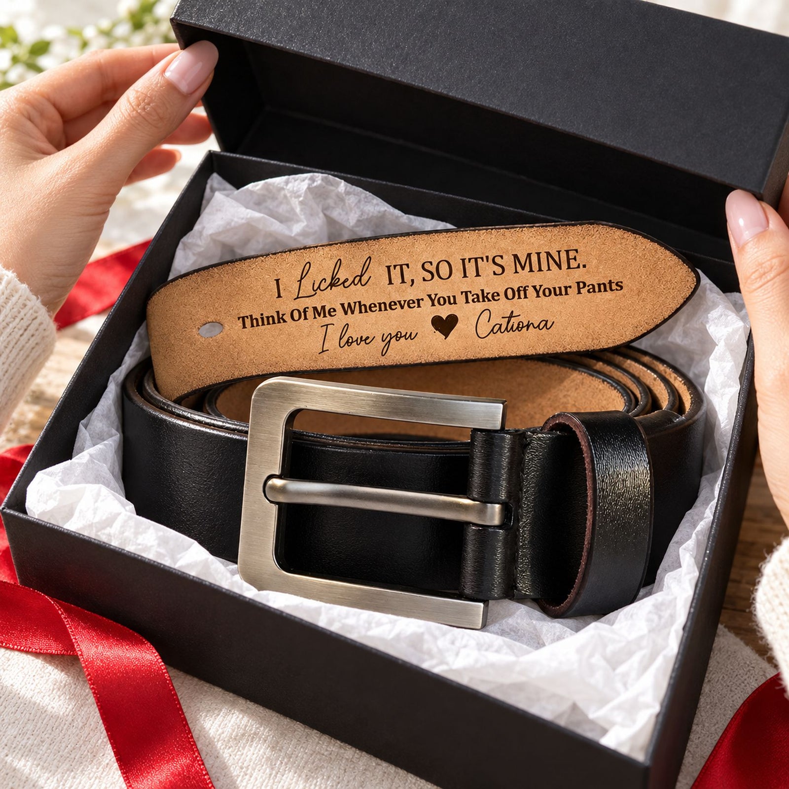Personalized engraved leather belt in an open gift box with tissue paper and holiday ribbon