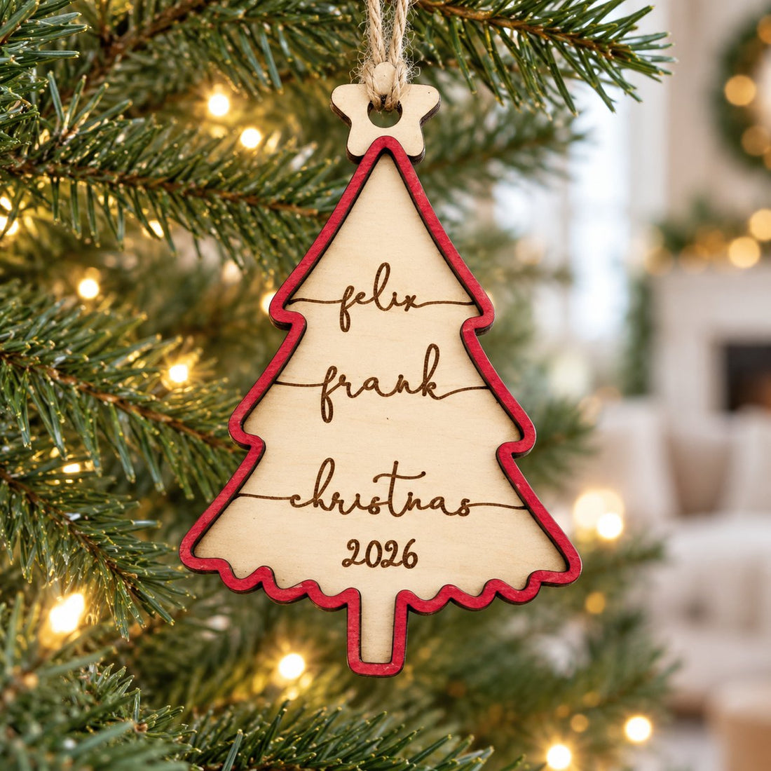 Personalized 2-layer wood family Christmas tree ornament hanging on a pine tree branch