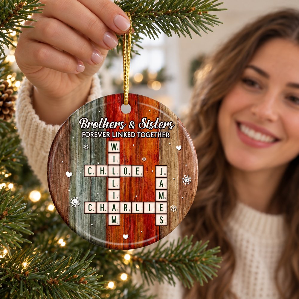 Personalized Brothers and Sisters crossword ceramic ornament being hung on a Christmas tree branch