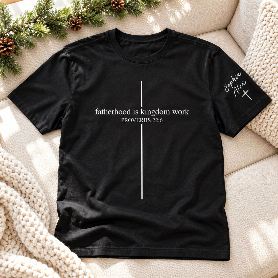 Fatherhood Is Kingdom Work custom dad t-shirt laid flat on sofa in holiday setting