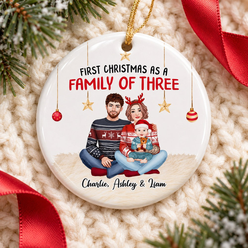 Babies 1st Christmas personalized ceramic ornament lying flat on a cozy cream knit surface with pine greenery