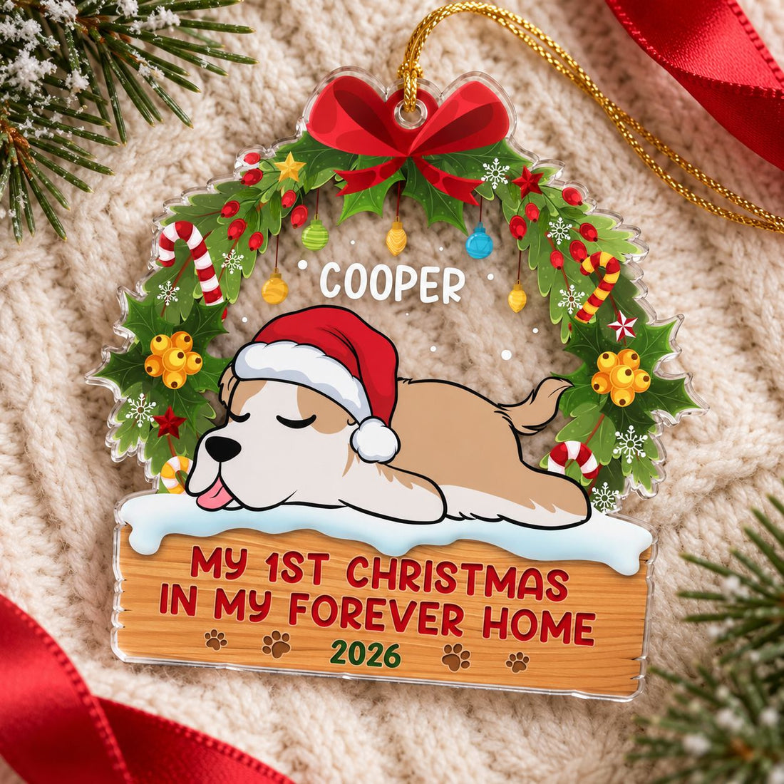 First Paws Under The Tree Cooper acrylic ornament lying flat on cozy cream knit fabric