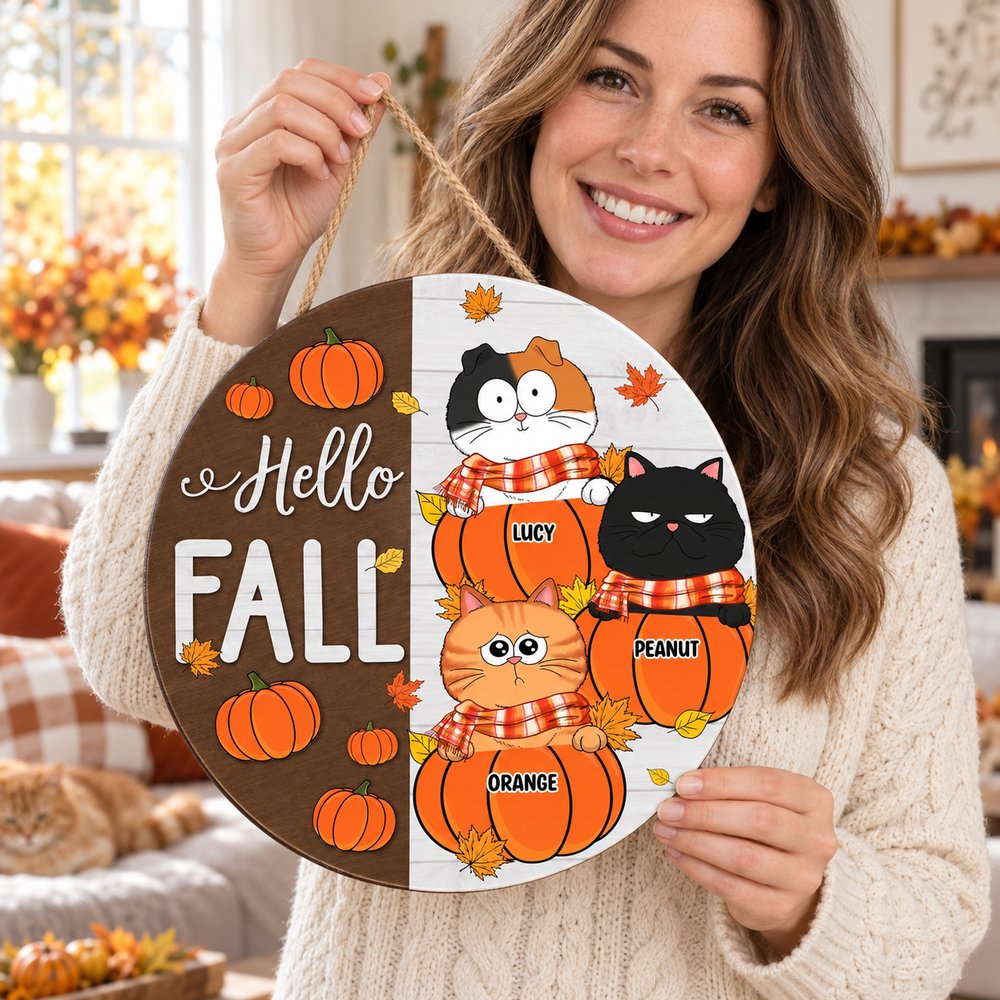 Cat mom holding her personalized Funny Cats Hello Fall round wood sign in a bright living room