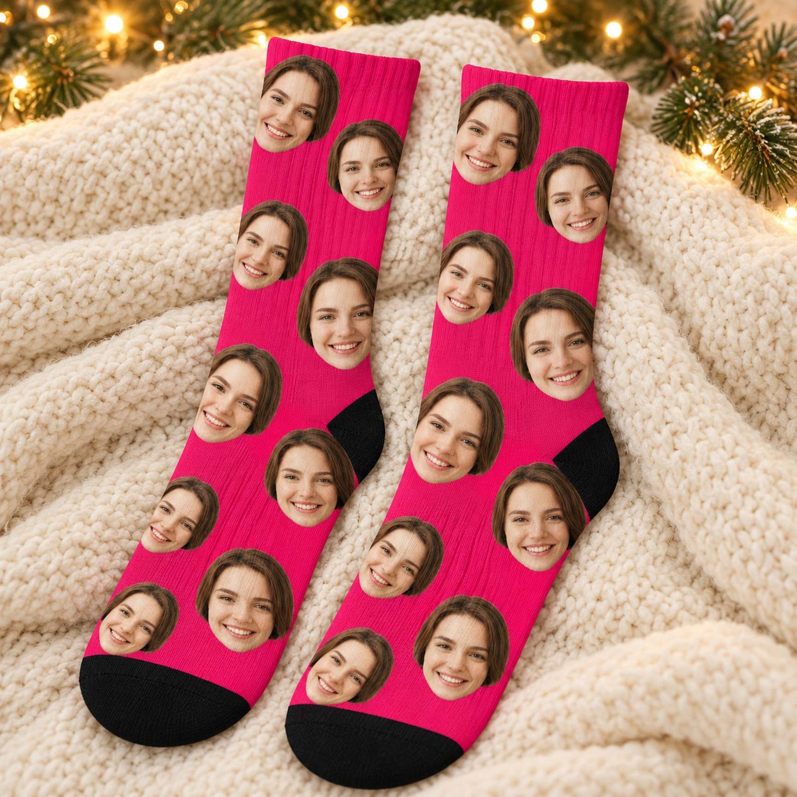 Custom face crew socks in hot pink laid flat on a cream knit blanket with holiday greenery