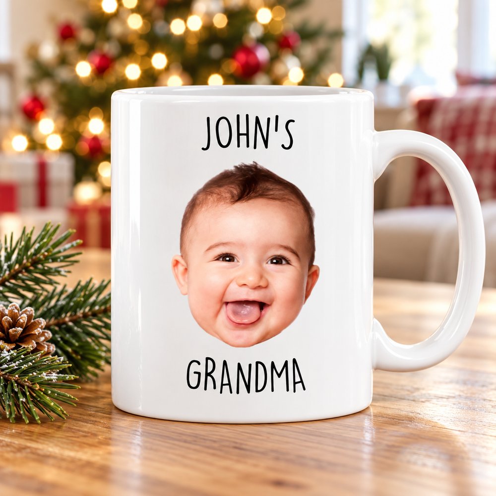 Custom photo Grandma baby face white ceramic mug on a table near a Christmas tree