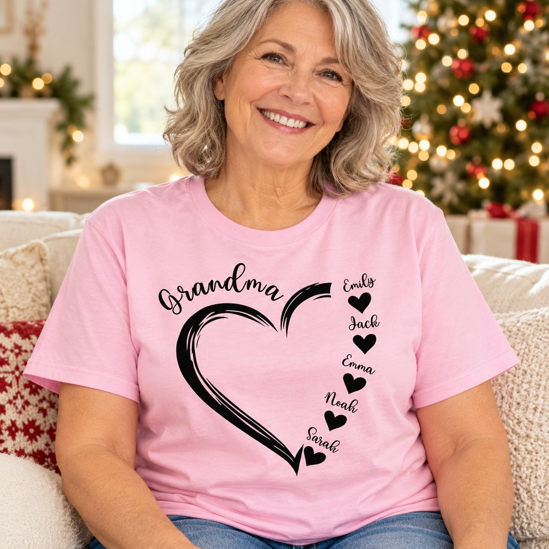 Grandma wearing personalized light pink sweetheart grandkids name t-shirt by Christmas tree