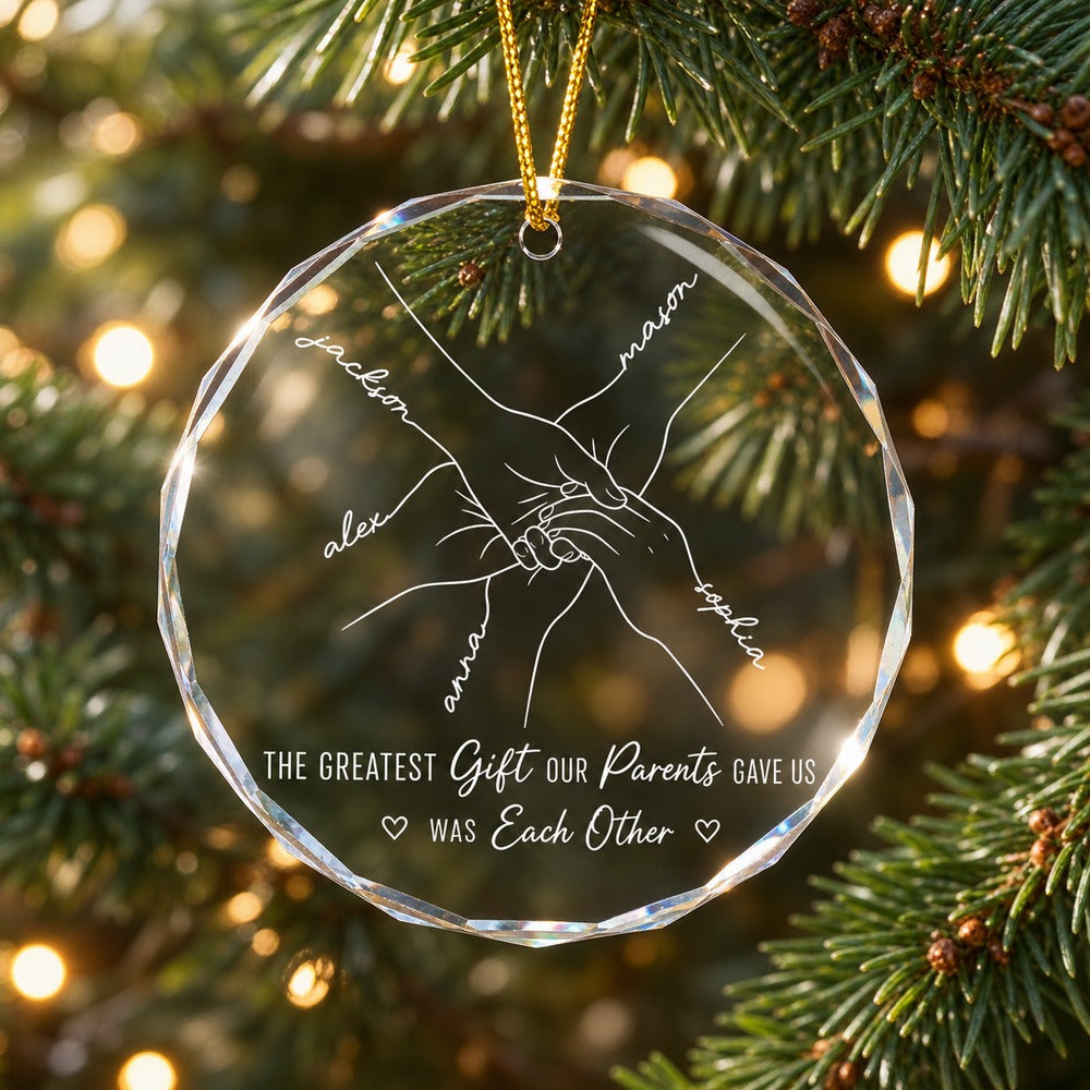 Personalized sibling hands line art circle glass ornament hanging on a Christmas tree branch