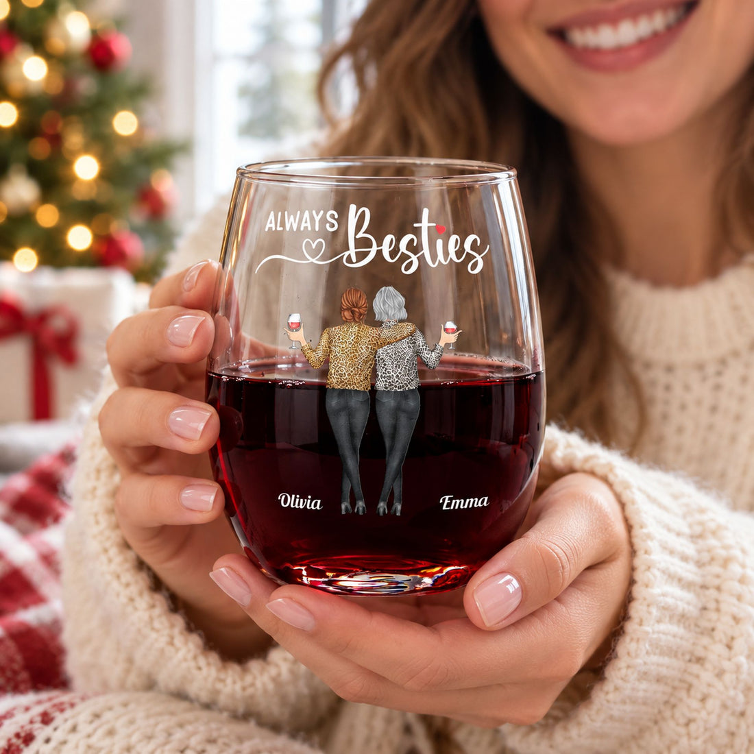 Woman in a cozy sweater holding her personalized Always Besties stemless wine glass with red wine