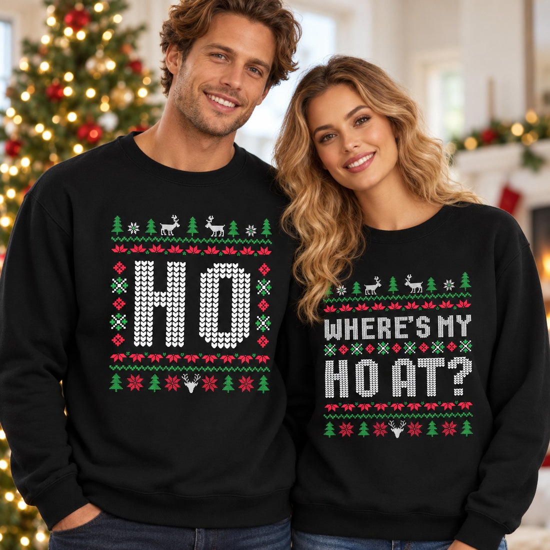 Husband and wife wearing matching black Ho and Wheres My Ho At ugly Christmas sweatshirts by tree