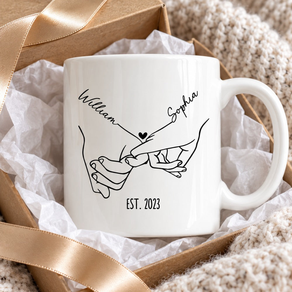 Personalized couple holding hands mug presented in a gift box with ribbon and tissue paper