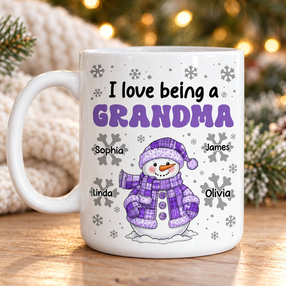 Personalized I Love Being A Grandma snowman mug on a holiday table with pine greenery