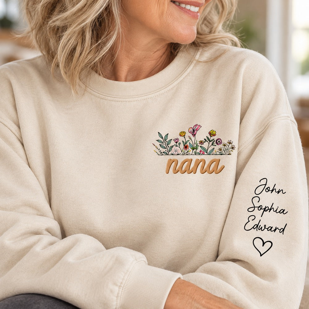Close-up of Nana floral chest print and personalized sleeve names on sand sweatshirt