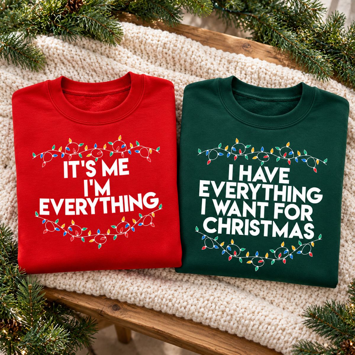 Matching red and green couple Christmas sweatshirts folded on a festive wooden bench with garland