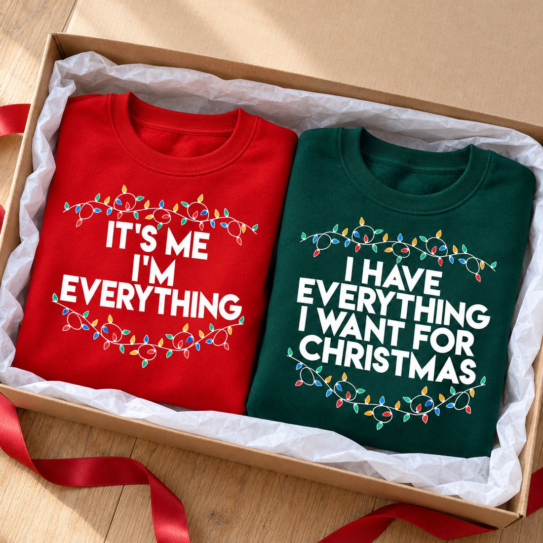 Matching red and green couple Christmas sweatshirts packed in an open holiday gift box