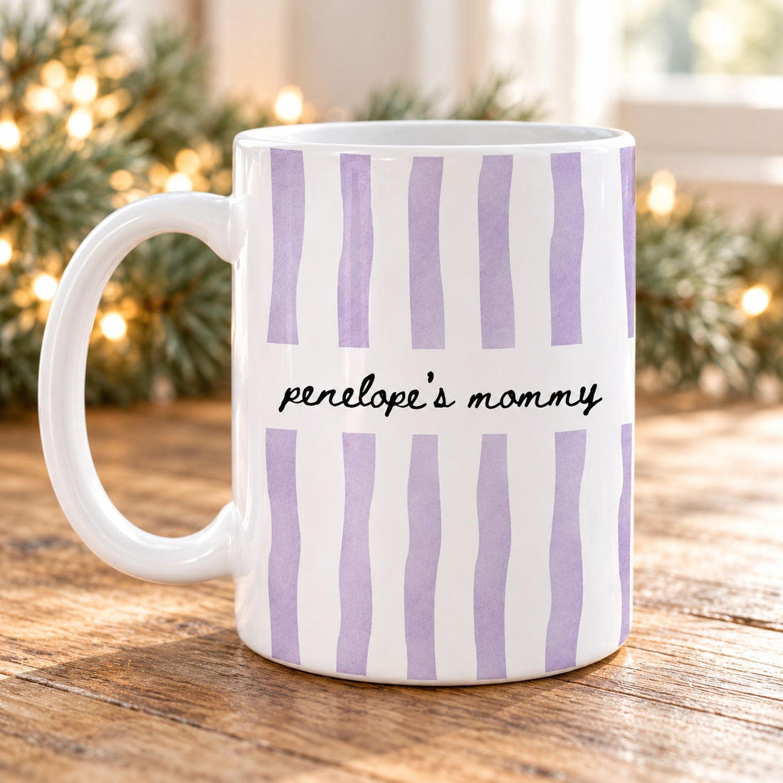 Personalized Penelope's Mommy watercolor stripe ceramic mug on a holiday table with pine garland