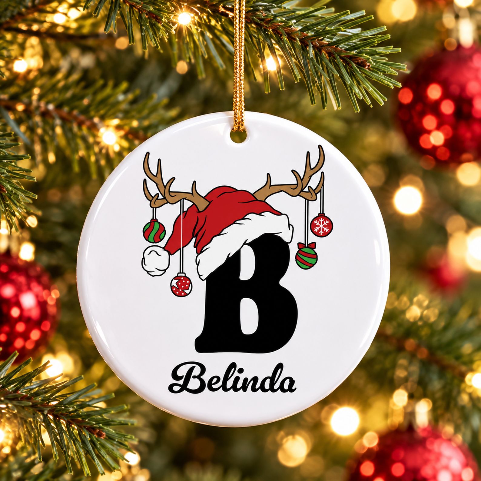 Personalized letter B ceramic Christmas ornament hanging on a pine tree branch