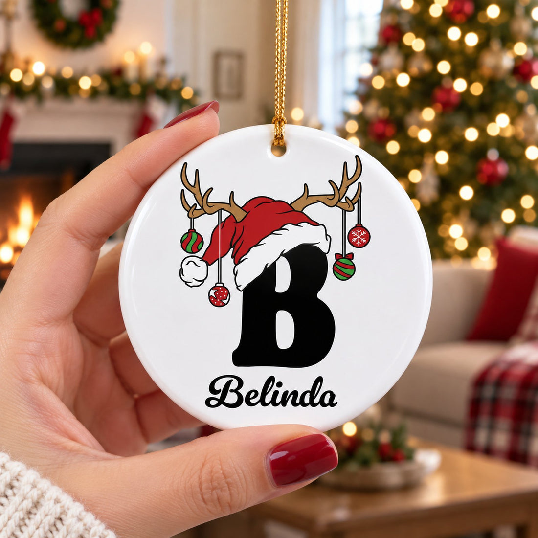 Hand holding the 3 inch custom initial family ceramic ornament to show scale